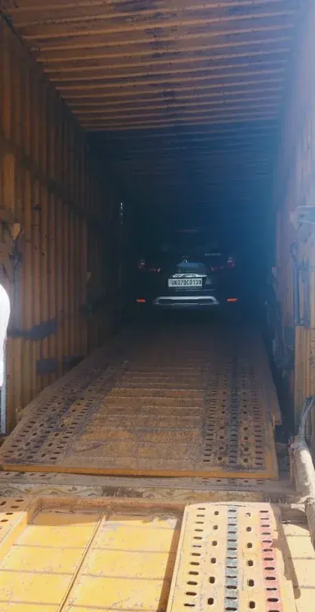 Car secured inside an enclosed car carrier container before leaving Dehradun